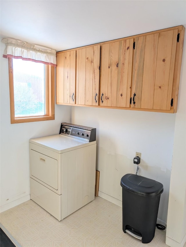 clothes washing area featuring washer / clothes dryer and cabinets