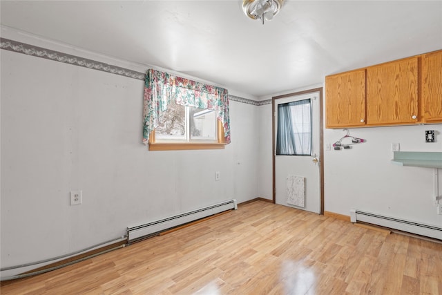 spare room featuring light wood-style flooring and a baseboard heating unit