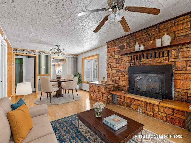 living room featuring light wood-type flooring, a fireplace, and ceiling fan