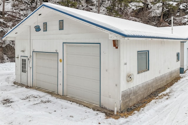 snow covered garage with a garage