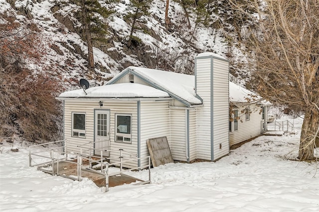 snow covered property featuring a chimney