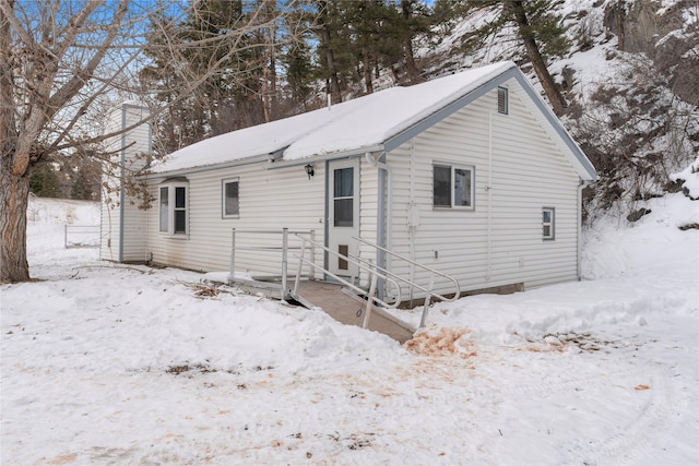 snow covered property featuring entry steps