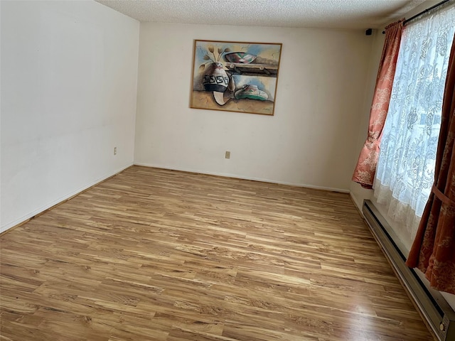 605 Idaho St, Deer Lodge, MT 59722 - unfurnished room with wood finished floors, a textured ceiling, a baseboard radiator, and baseboards