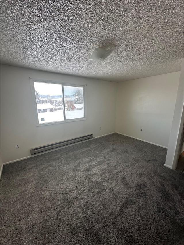 605 Idaho St, Deer Lodge, MT 59722 - spare room featuring a baseboard heating unit, carpet flooring, a textured ceiling, and baseboards