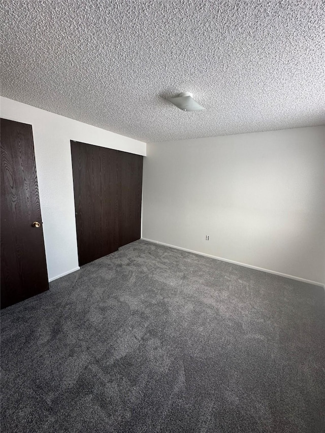 605 Idaho St, Deer Lodge, MT 59722 - unfurnished bedroom with dark colored carpet, a textured ceiling, and a closet
