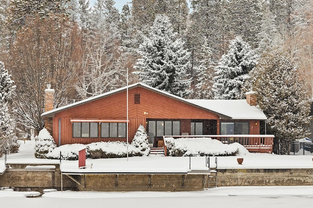 view of snow covered back of property