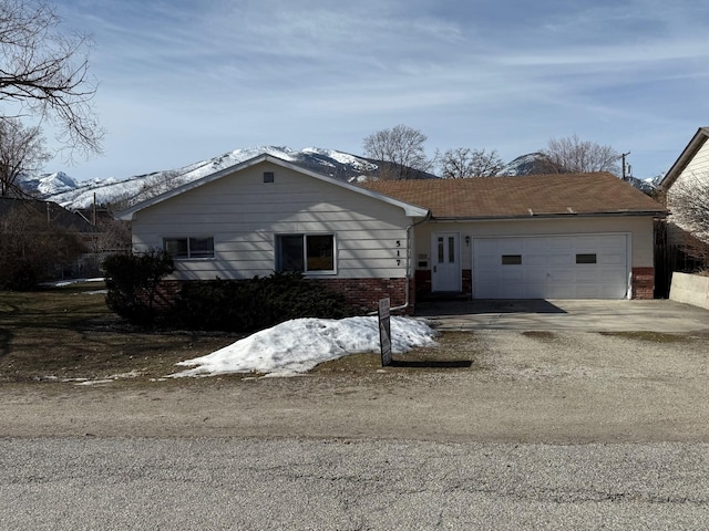 view of front of property featuring brick siding, an attached garage, and driveway