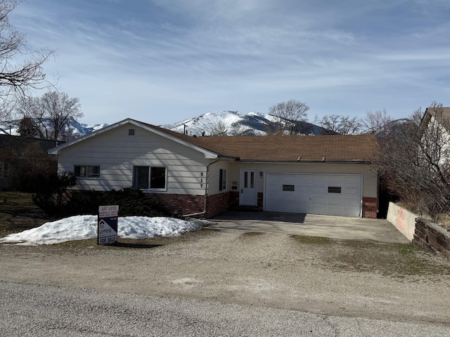 ranch-style house with brick siding, an attached garage, and driveway