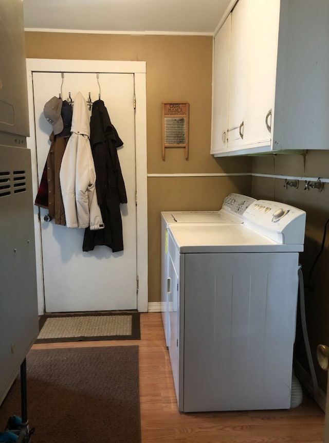 200 Cleveland Rd, Chinook, MT 59523 - washroom featuring cabinet space, washing machine and clothes dryer, and light wood-style flooring