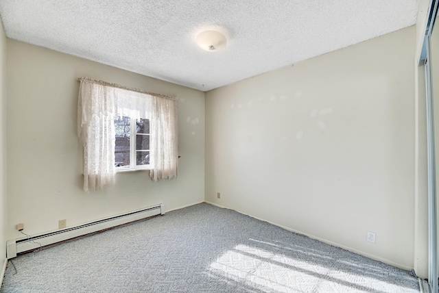 carpeted empty room featuring baseboard heating and a textured ceiling