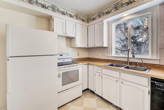 kitchen featuring a healthy amount of sunlight, sink, white appliances, and white cabinets