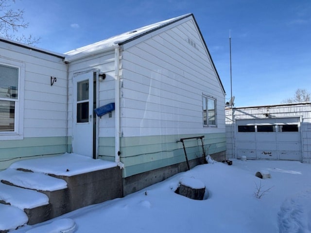 view of snow covered exterior featuring a garage