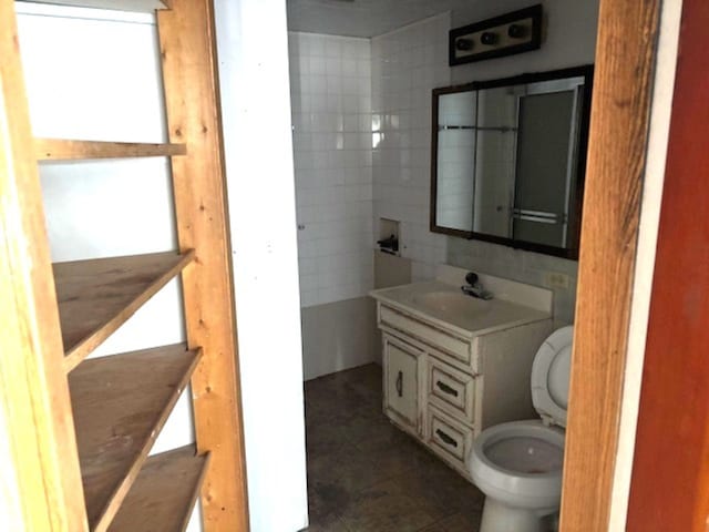 bathroom featuring tile patterned flooring, vanity, tile walls, and toilet