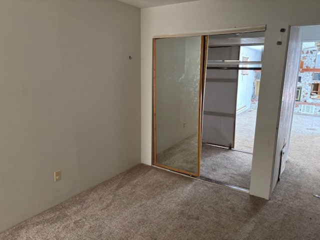 unfurnished bedroom with carpet floors and a closet