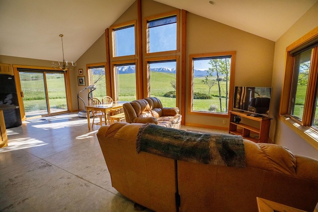 living room with concrete flooring, high vaulted ceiling, and an inviting chandelier