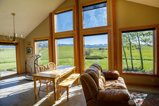 sunroom / solarium featuring a chandelier, vaulted ceiling, and a rural view