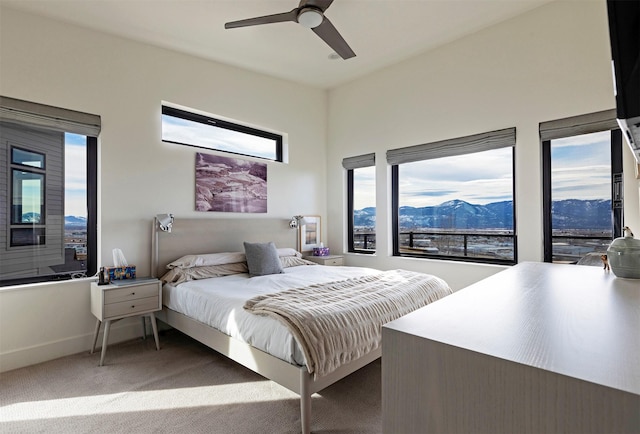 bedroom with a ceiling fan, baseboards, and carpet flooring