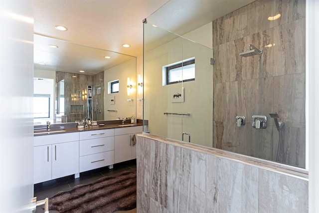 bathroom featuring tile patterned flooring, a sink, a shower stall, and double vanity