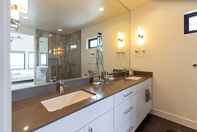 full bath with double vanity, a stall shower, connected bathroom, and a sink