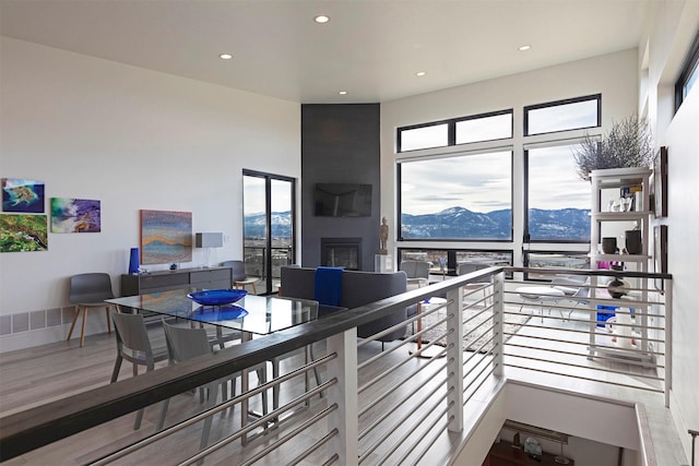 interior space featuring a large fireplace, baseboards, wood finished floors, and recessed lighting
