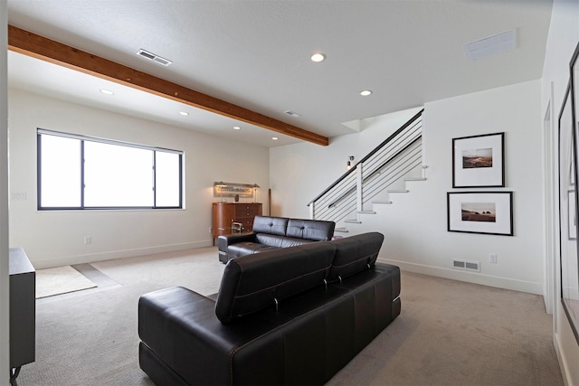 carpeted living room featuring beam ceiling