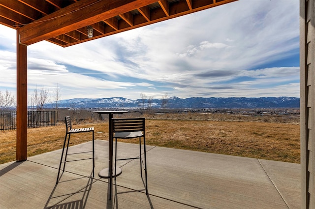 view of patio / terrace featuring a mountain view and fence