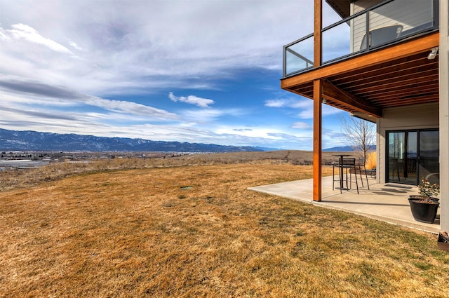 view of yard featuring a patio area and a mountain view