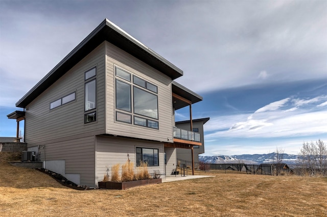 back of property with a patio, a lawn, fence, a mountain view, and cooling unit