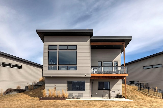 back of property featuring a patio, fence, and a balcony