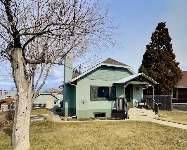 bungalow-style home featuring a front lawn, stucco siding, fence, and a chimney