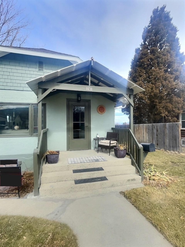 exterior space featuring stucco siding and fence