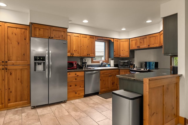 kitchen with appliances with stainless steel finishes, sink, and kitchen peninsula