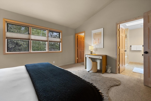 carpeted bedroom with lofted ceiling and ensuite bath