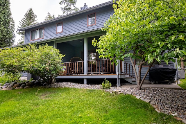 rear view of property featuring a yard