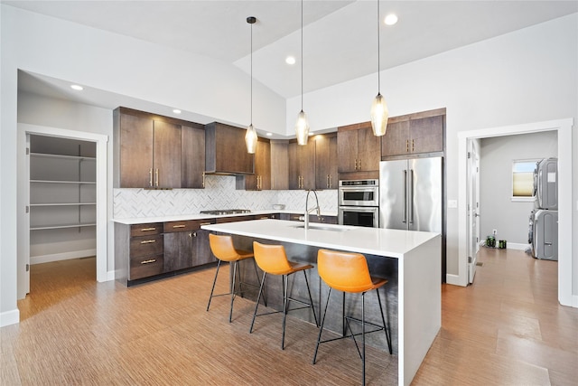 kitchen featuring appliances with stainless steel finishes, sink, dark brown cabinets, and a breakfast bar