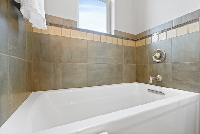 bathroom with a bathing tub and tile walls