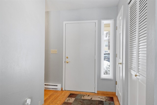 tiled foyer entrance with stairway, a baseboard radiator, and baseboards