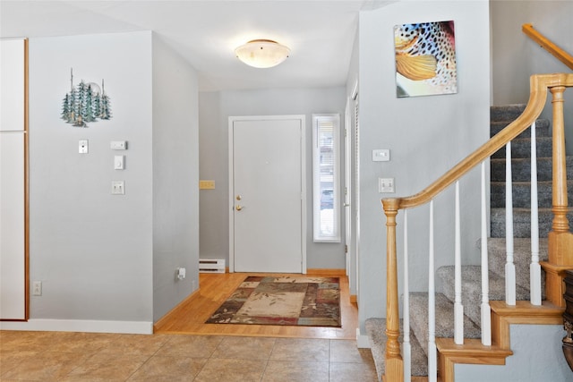 tiled foyer featuring baseboards, stairs, and a baseboard heating unit