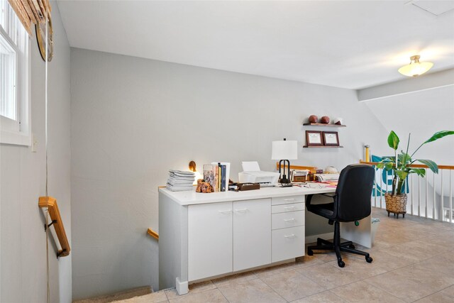 office area with light tile patterned floors and built in study area