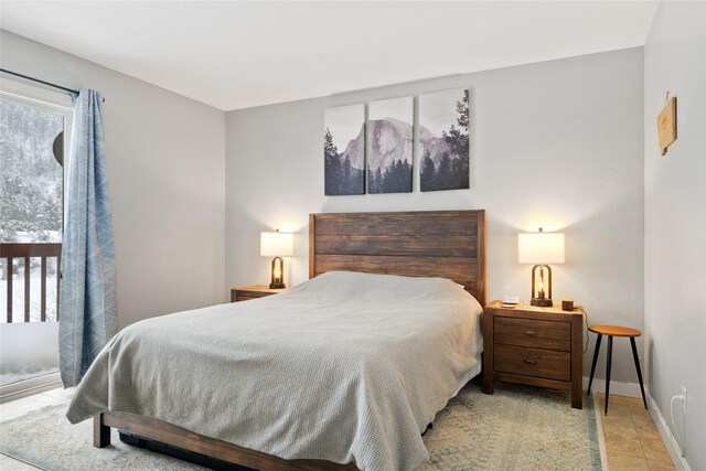 bedroom with light tile patterned floors and baseboards