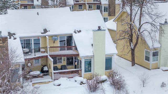 view of front of property with a chimney and a balcony