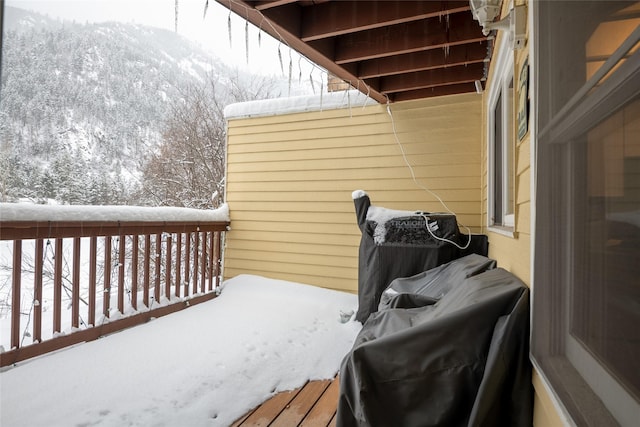 snow covered deck featuring a mountain view