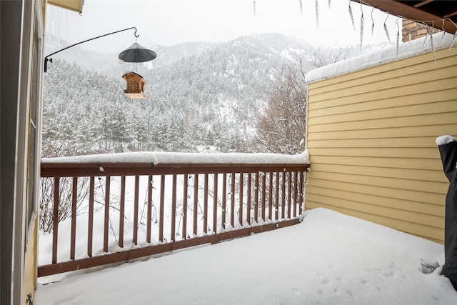 snow covered deck with a mountain view