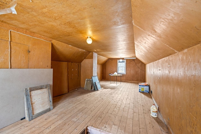 additional living space featuring light hardwood / wood-style flooring and vaulted ceiling