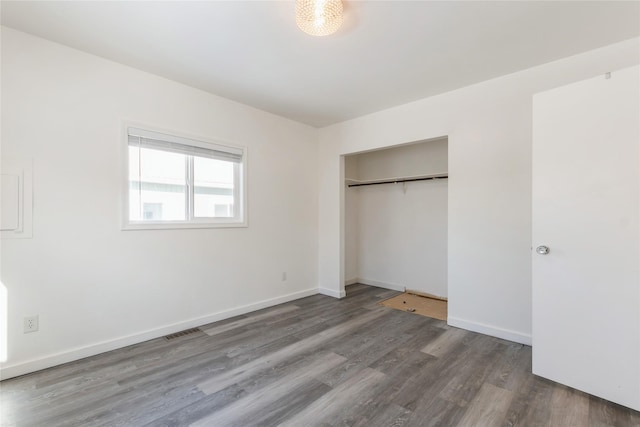 unfurnished bedroom with a closet and dark hardwood / wood-style floors