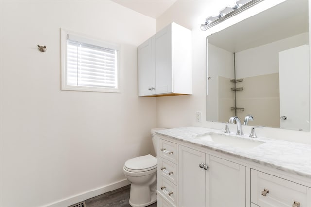 bathroom featuring toilet, vanity, and hardwood / wood-style floors