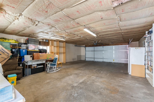 garage featuring white refrigerator and a garage door opener