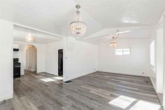 unfurnished room featuring vaulted ceiling, an inviting chandelier, and hardwood / wood-style floors