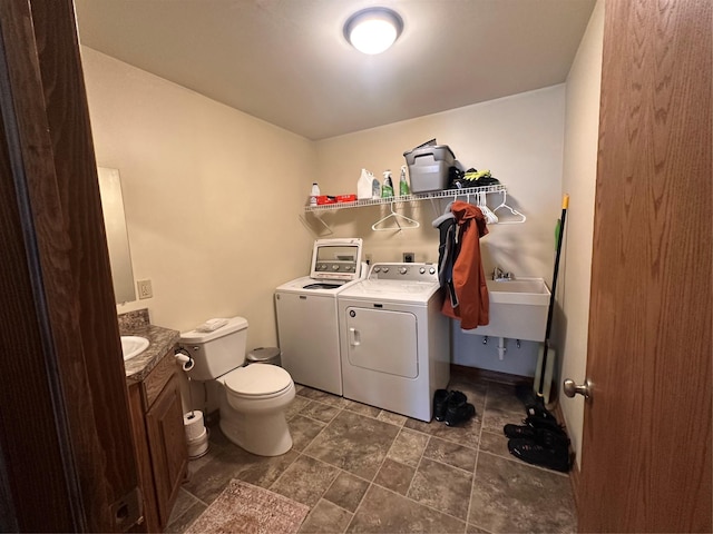 laundry room featuring laundry area, washing machine and dryer, and a sink