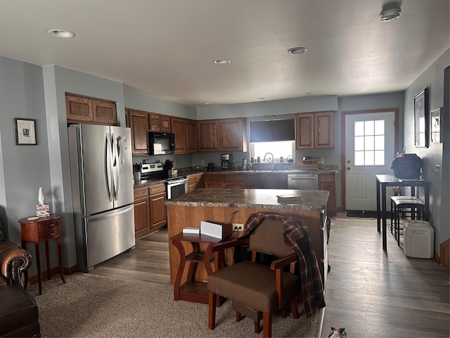 kitchen featuring appliances with stainless steel finishes, a center island, and brown cabinets